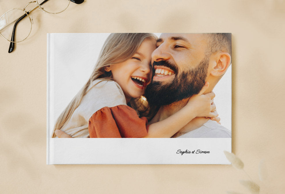 Livre photo A5 paysage fermé avec une photo d'un homme et sa fille sur la page de couverture avec le texte "Sophia et Simon".