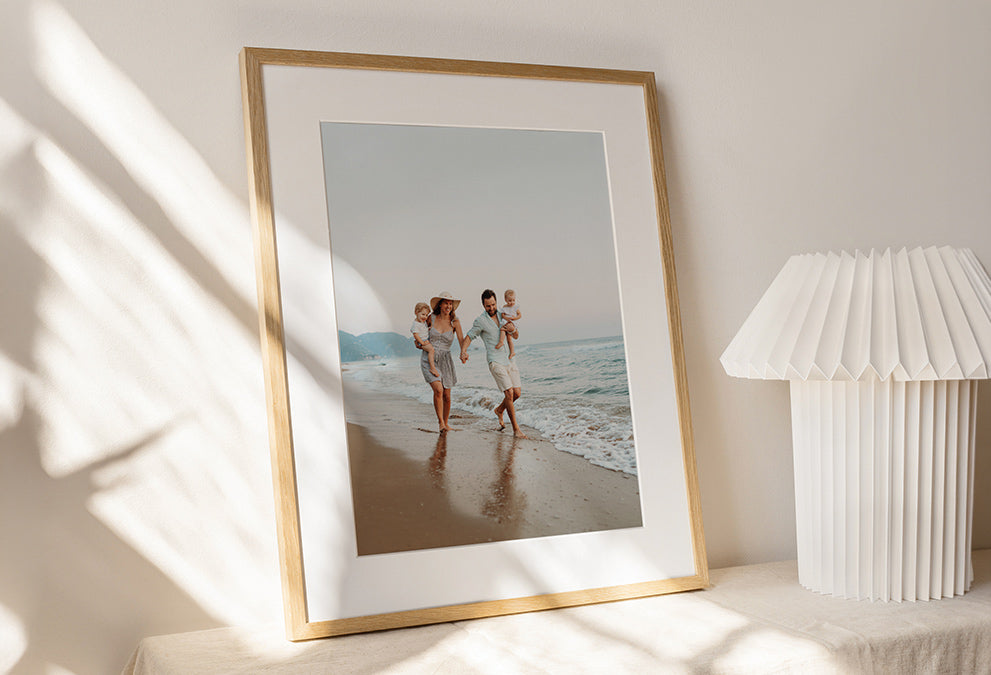 Cadre photo en bois personnalisé avec une photo de famille marchant au bord de la plage.