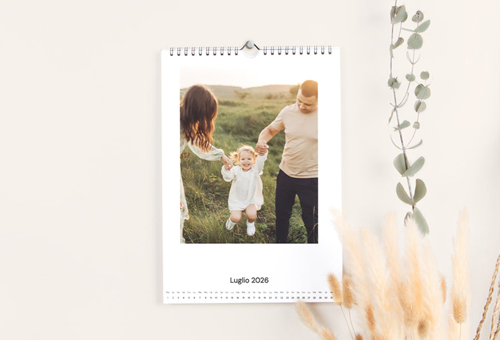 Calendario foto da muro personalizzato che mostra una pagina con foto di famiglia all'aperto.