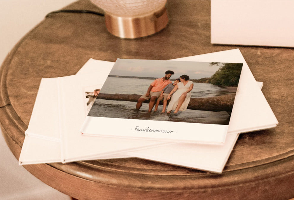 Personalisierter Fotoband mit einem Familienfoto am Strand auf dem Cover und dem Text ‚Ein Sommer mit der Familie‘.