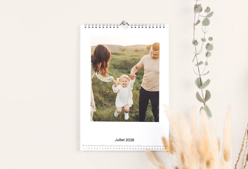 Calendrier photo mural personnalisé affichant une page avec une photo de famille en plein air.