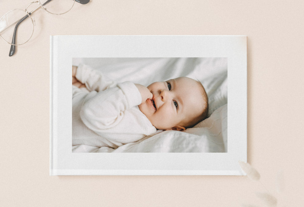 Fotobuch A5 Landschaft geschlossen mit einem lächelnden Baby auf einer Seite.