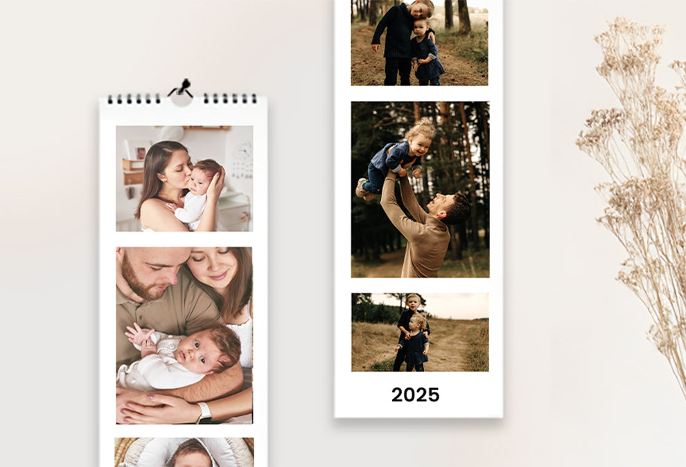 Deux calendriers muraux longs et portrait accrochés à un mur et ouvert sur la page de couverture qui montre plusieurs photos de famille et sur l'un deux le texte "2025" sous les photos.